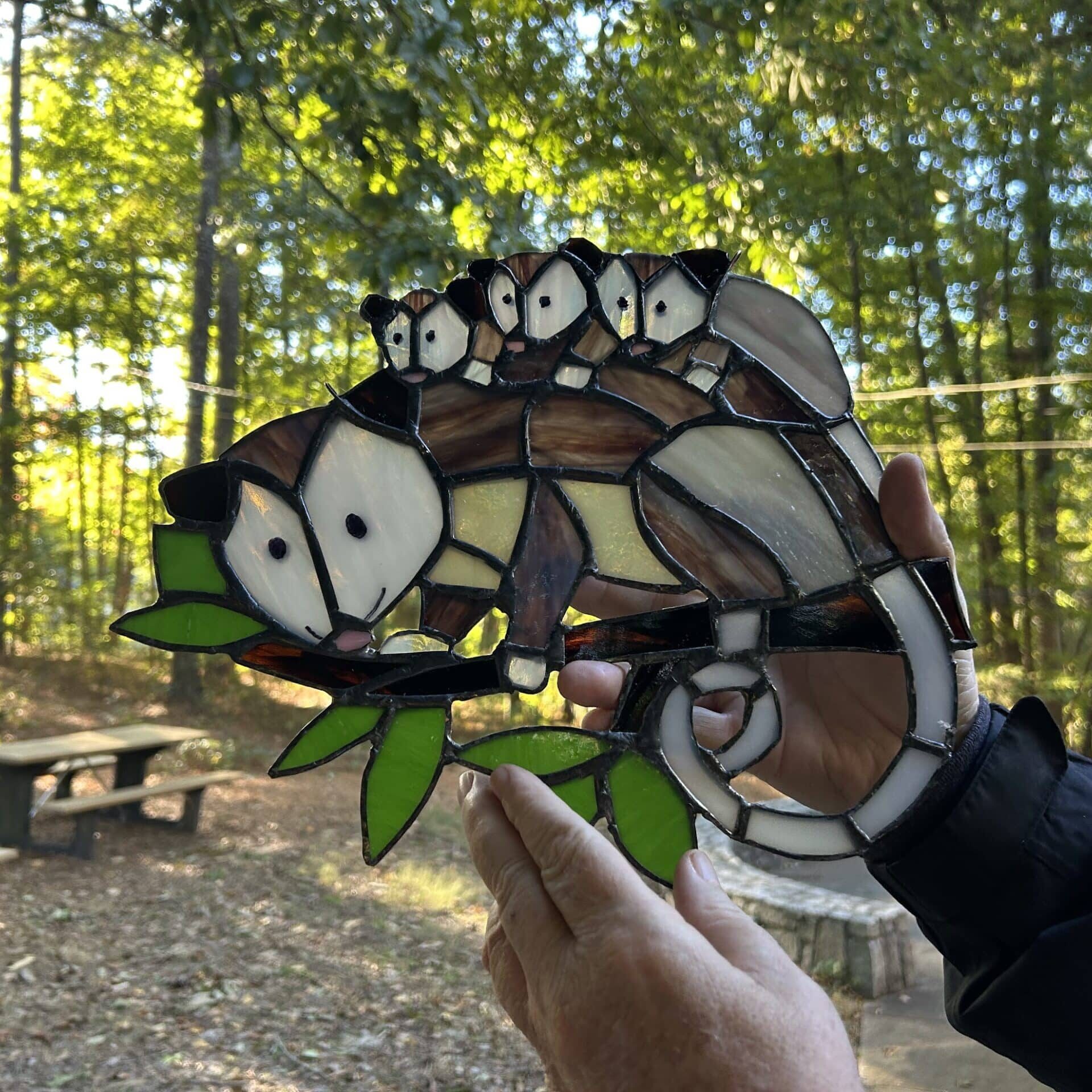 stained glass opossum with three babies on her back